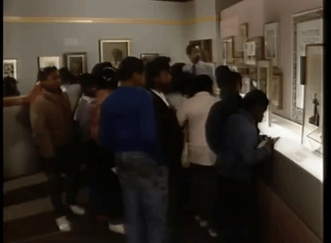 A school group gathered around an exhibit at Smithsonian's Anacostia Community Museum in the 1980s. Children gather around an exhibit.