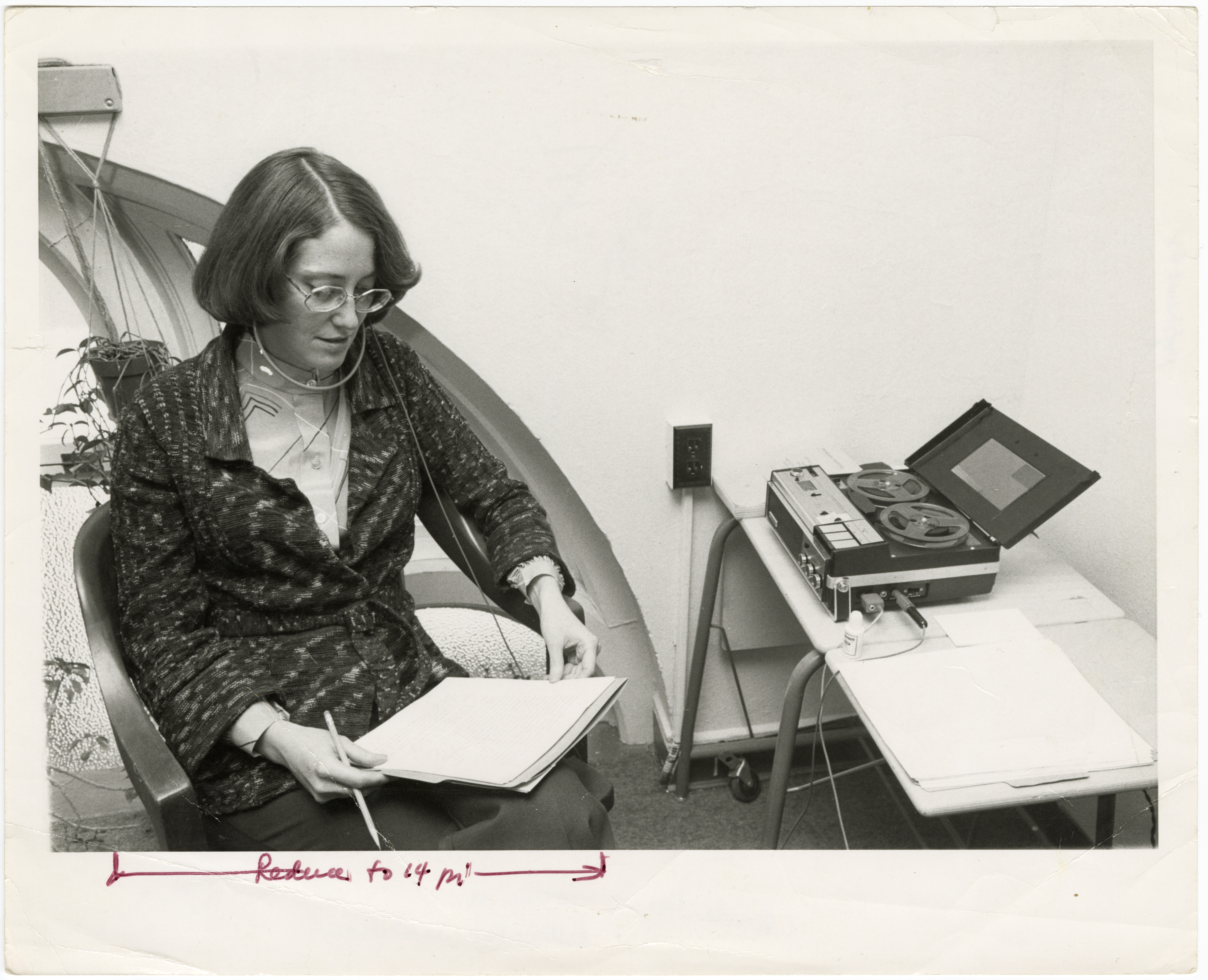 Historian Pamela Henson Listens to Oral History Interview, 1977, by Richard K. Hofmeister. Smithsonian Institution Archives, Record Unit 371, Image no. 77-365-04A. Pam Henson sits at a desk with an older audio recording machine.