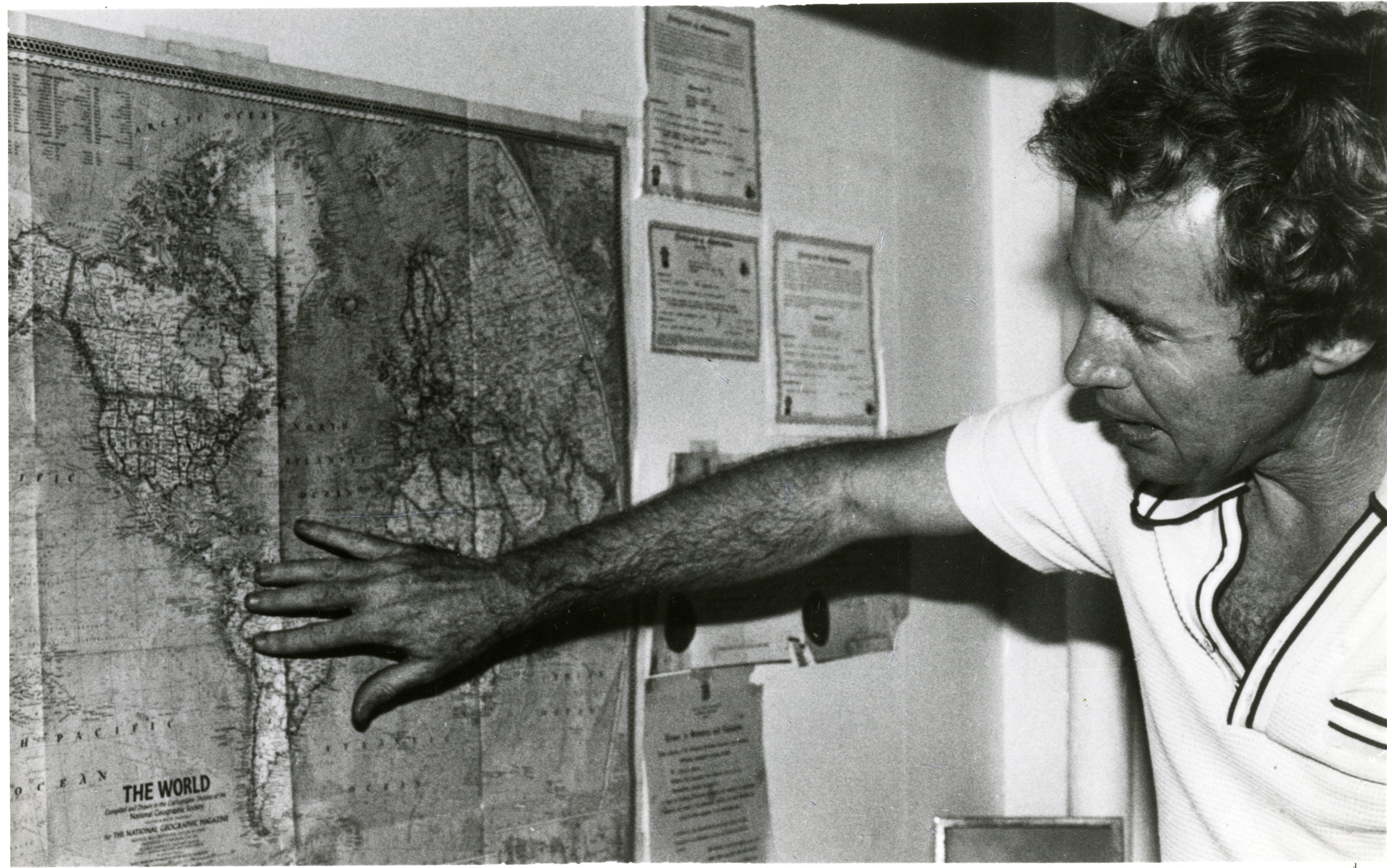 Dr. Neal Smith Traces on a Map the Limited Distribution of the Day-flying Moth, 1981, by Richard K. Hofmeister. Smithsonian Institution Archives, Accession 98-016, Image no. SIA2011-1162. A man points to South America on a map of the world.