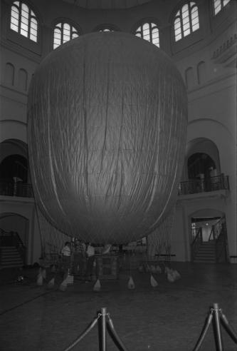 Workers prepare a hot air balloon to hang in the Rotunda of the Arts and Industries Building. The centerpiece of the Charles Eames exhibit 