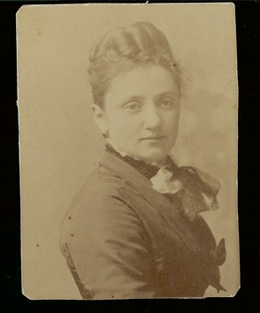 A woman, Matilda Coxe Stevenson, sits to have her picture taken. She looks at the camera. 