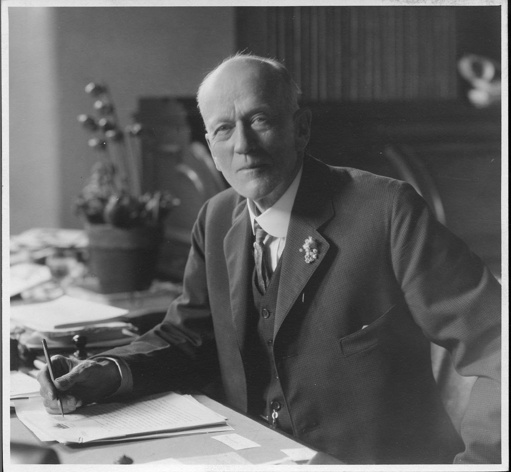 Charles Doolittle Walcott (1850-1927), fourth Secretary of the Smithsonian Institution from 1907 to 1927.  Walcott is seated at his desk writing. Smithsonian Institution Archives, Record Unit 95, Box 23, Folder 23.
