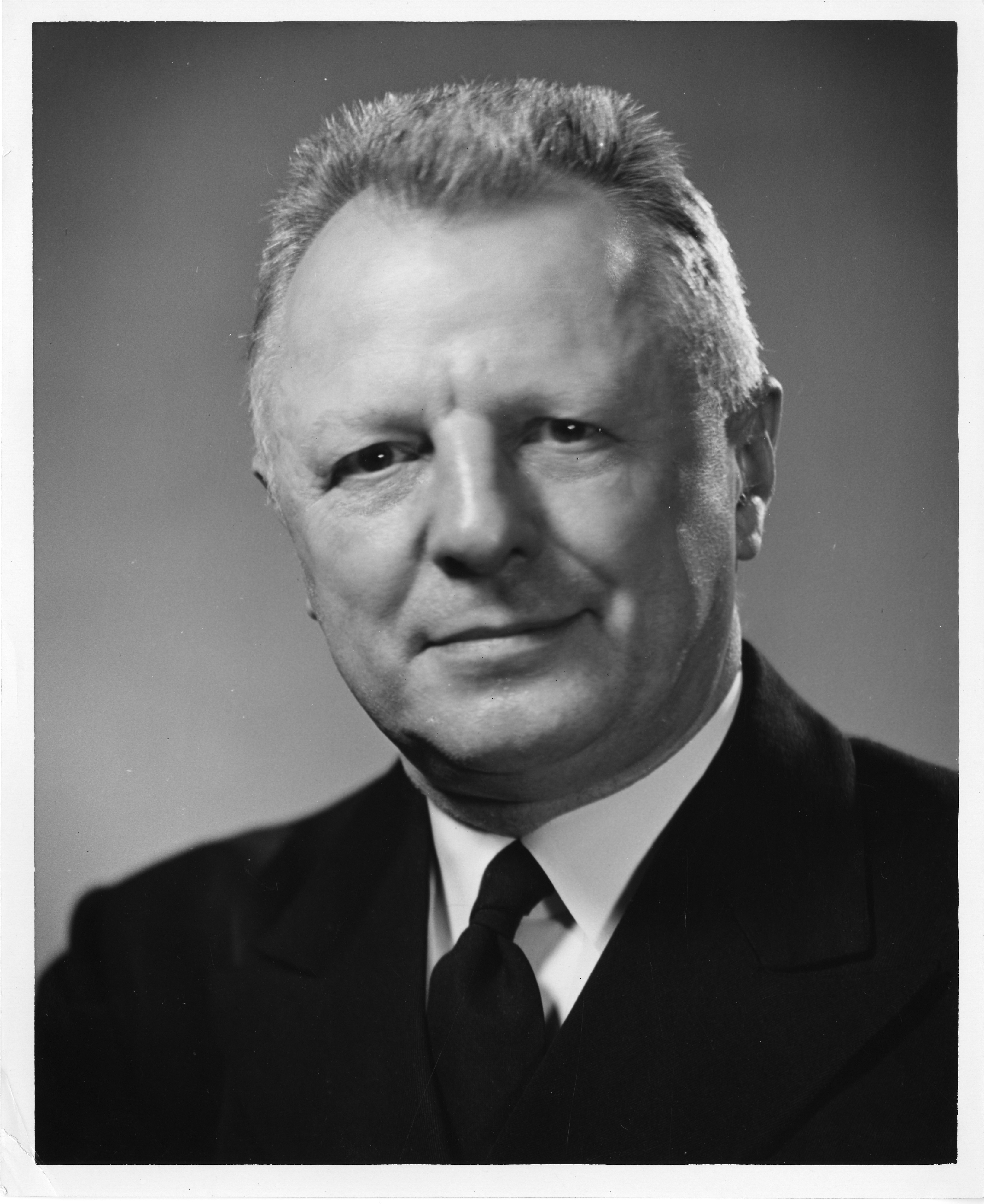 Portrait photograph of a person in a suit. 