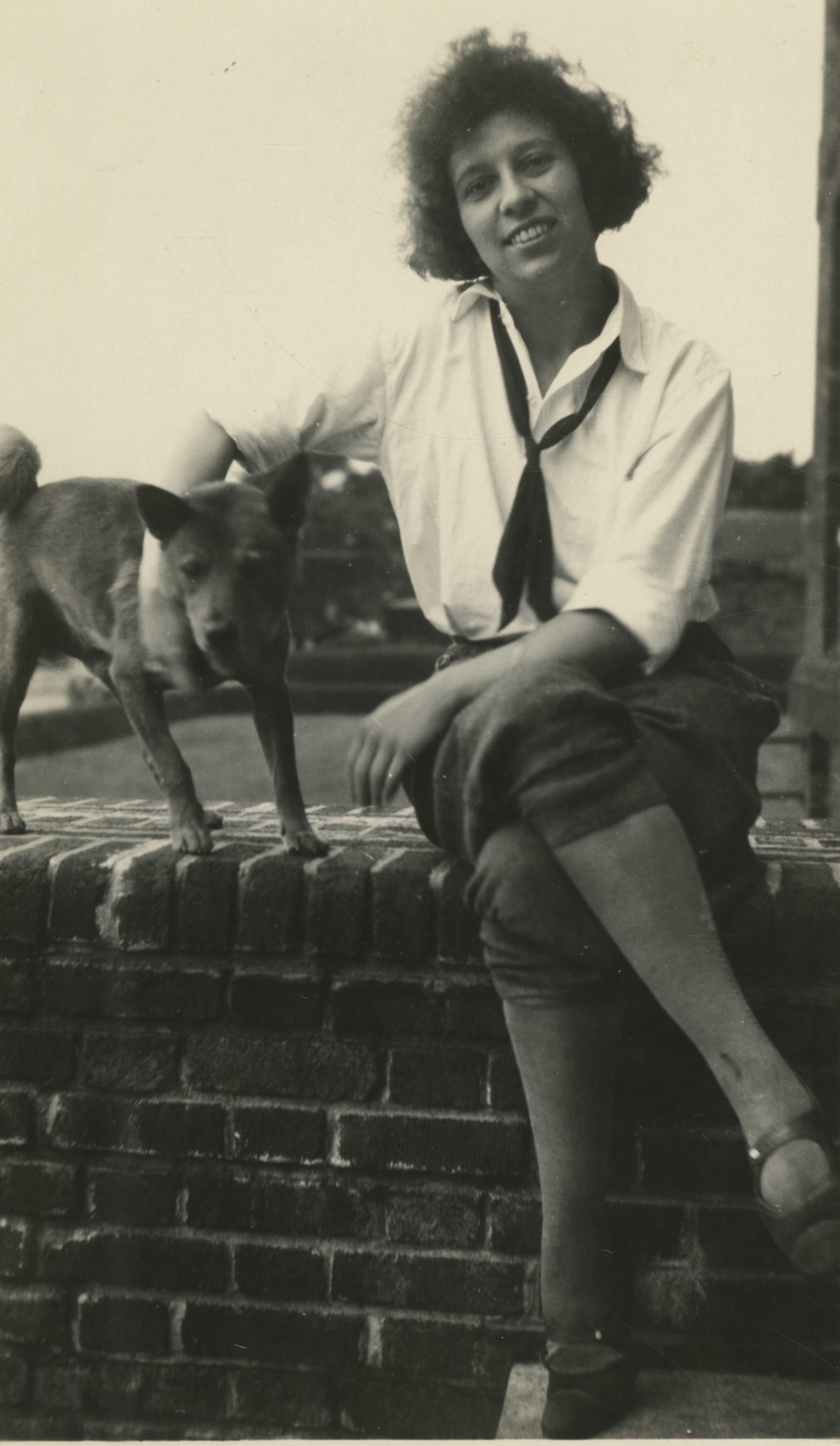 Black and white image of woman seated with a dog.