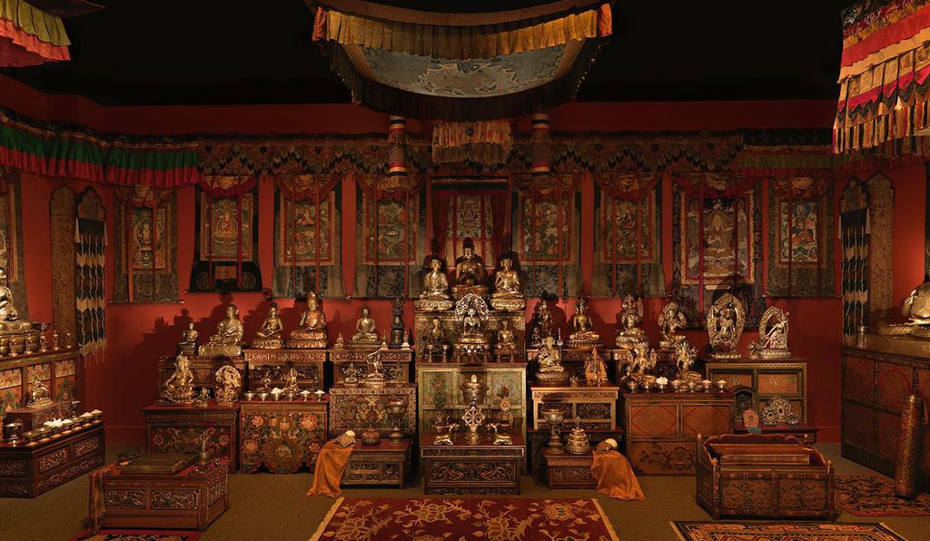 brightly enshrined orange/red room filled with brightly colored boxes with buddha statues on top