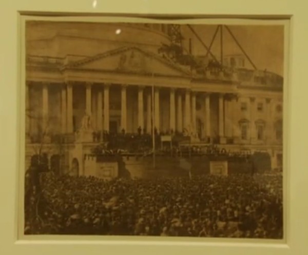 Sepia toned photograph of large crowd around U.S. Capitol as Abraham Lincoln is sworn in.