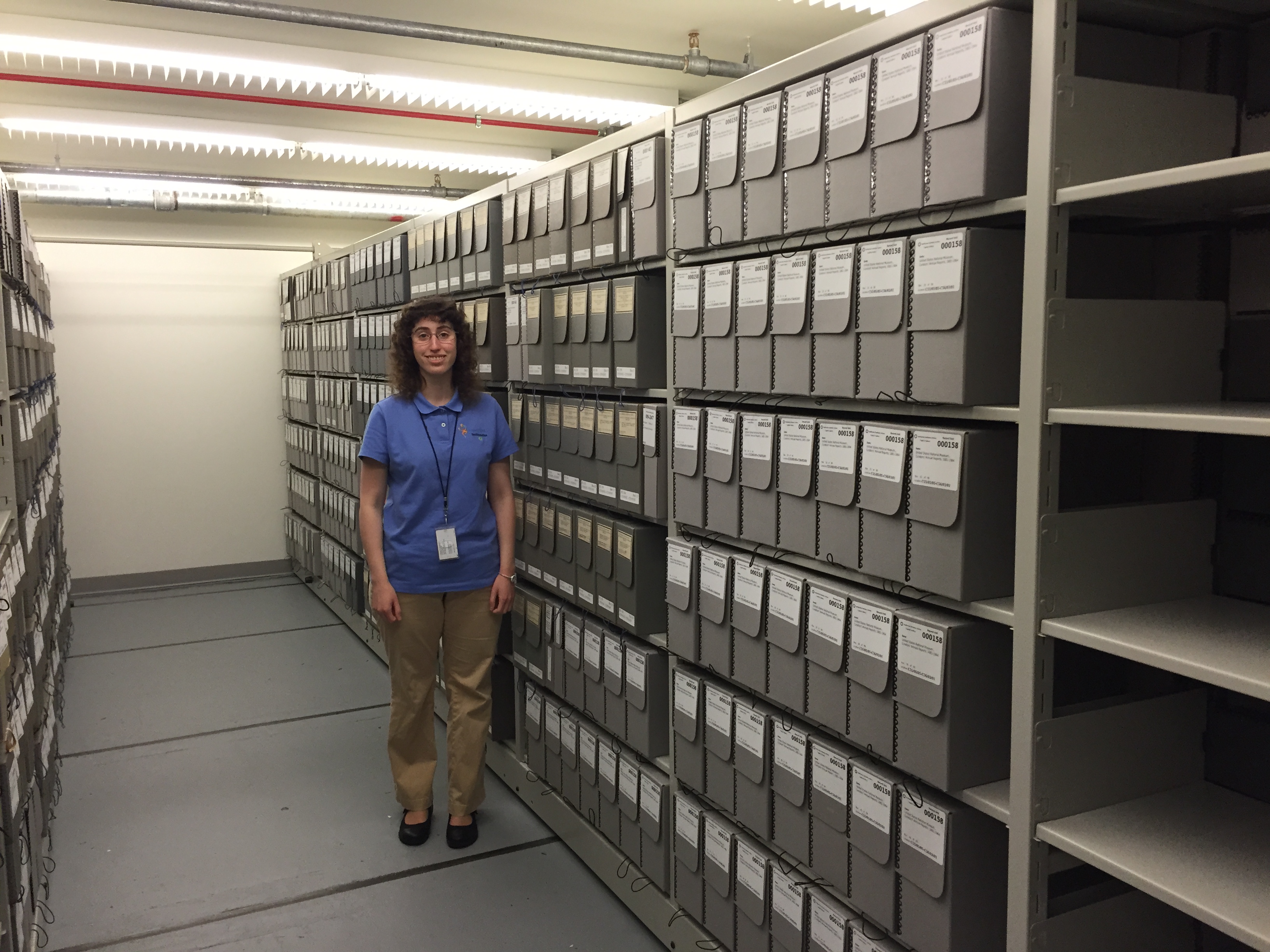 Heather in our collections storage space, alongside the collections she has helped rehouse.