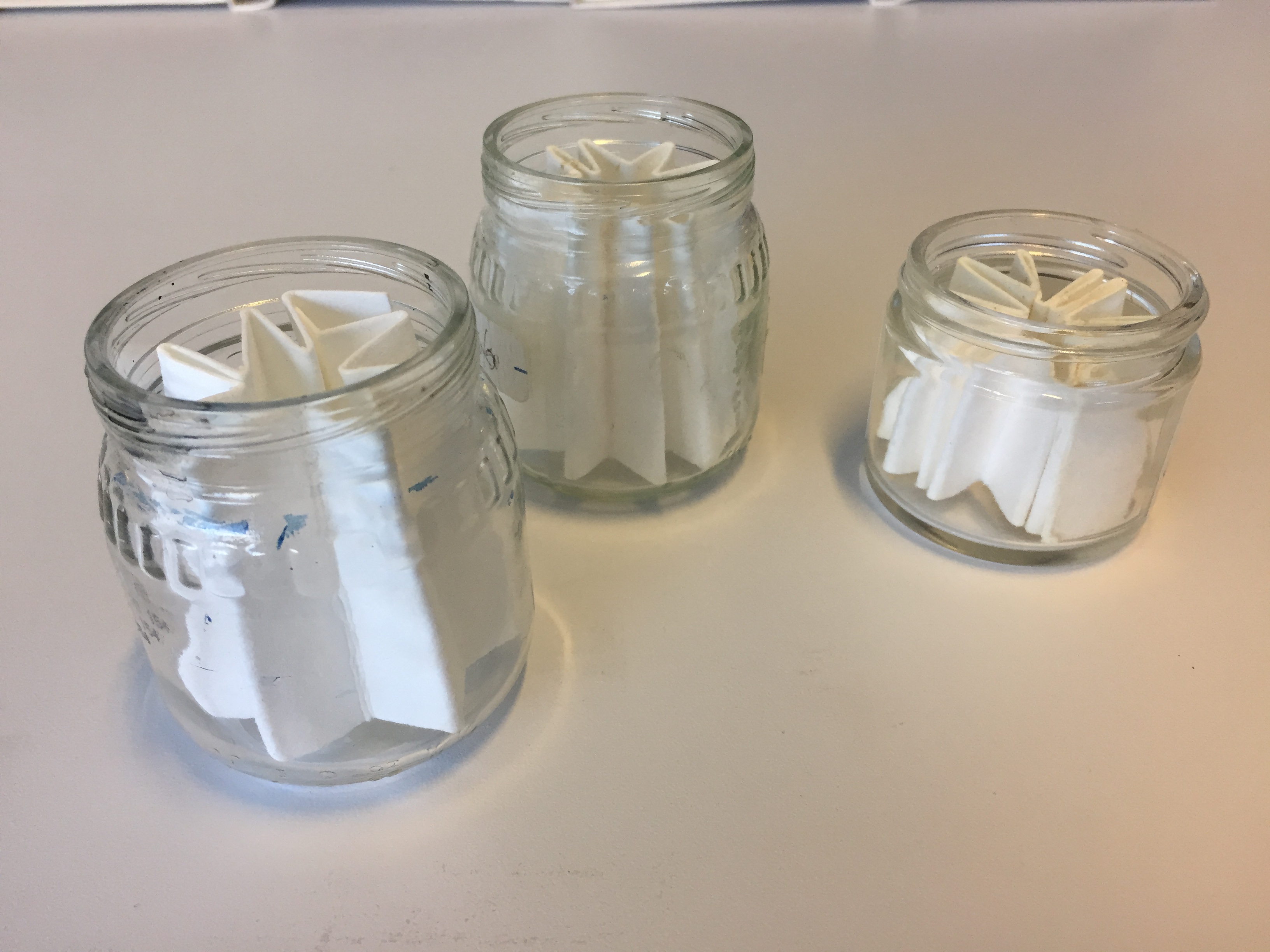 3 glass jars with folded paper