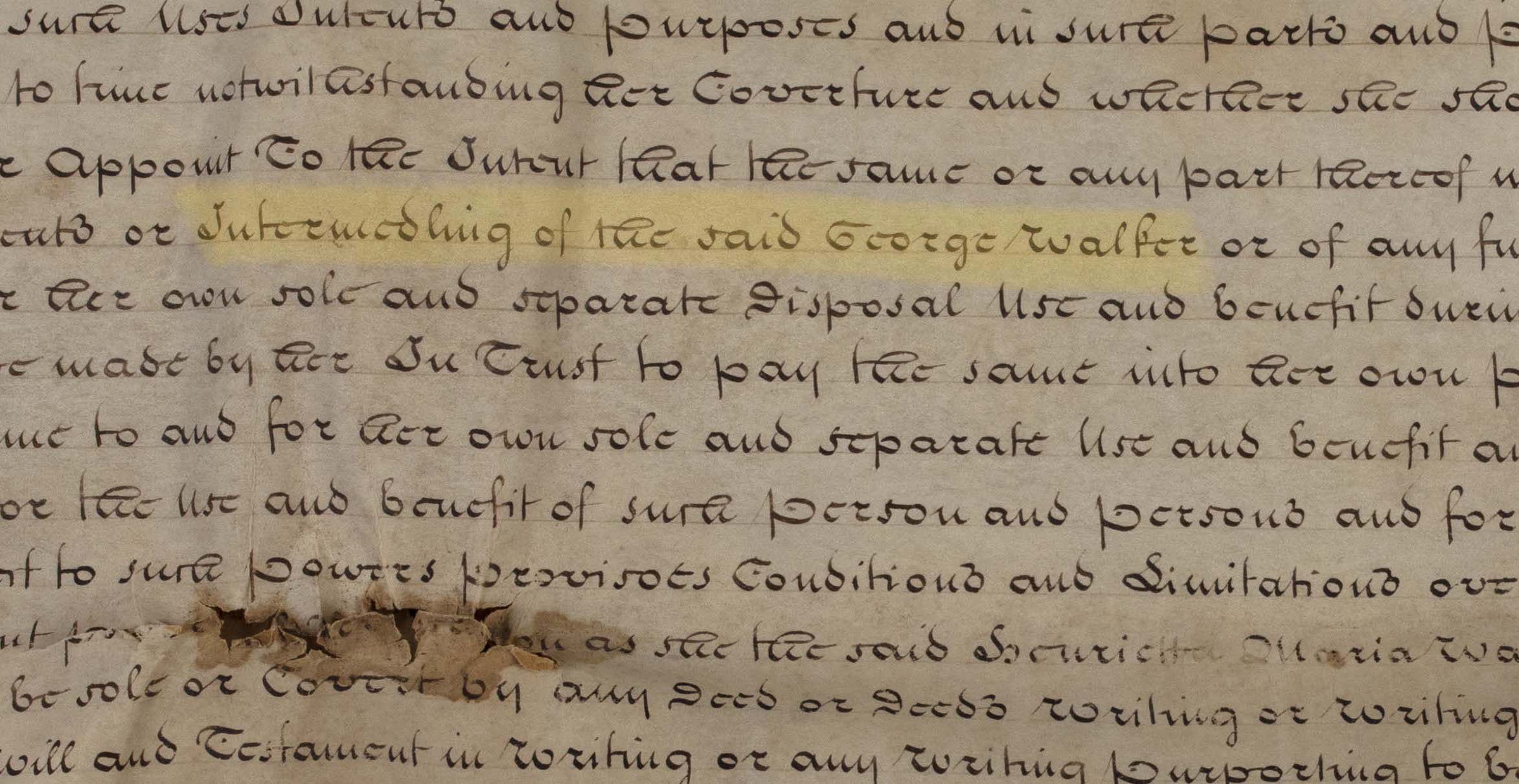 : A close-up view of a parchment sheet, with a damaged portion at lower left, covered closely with b