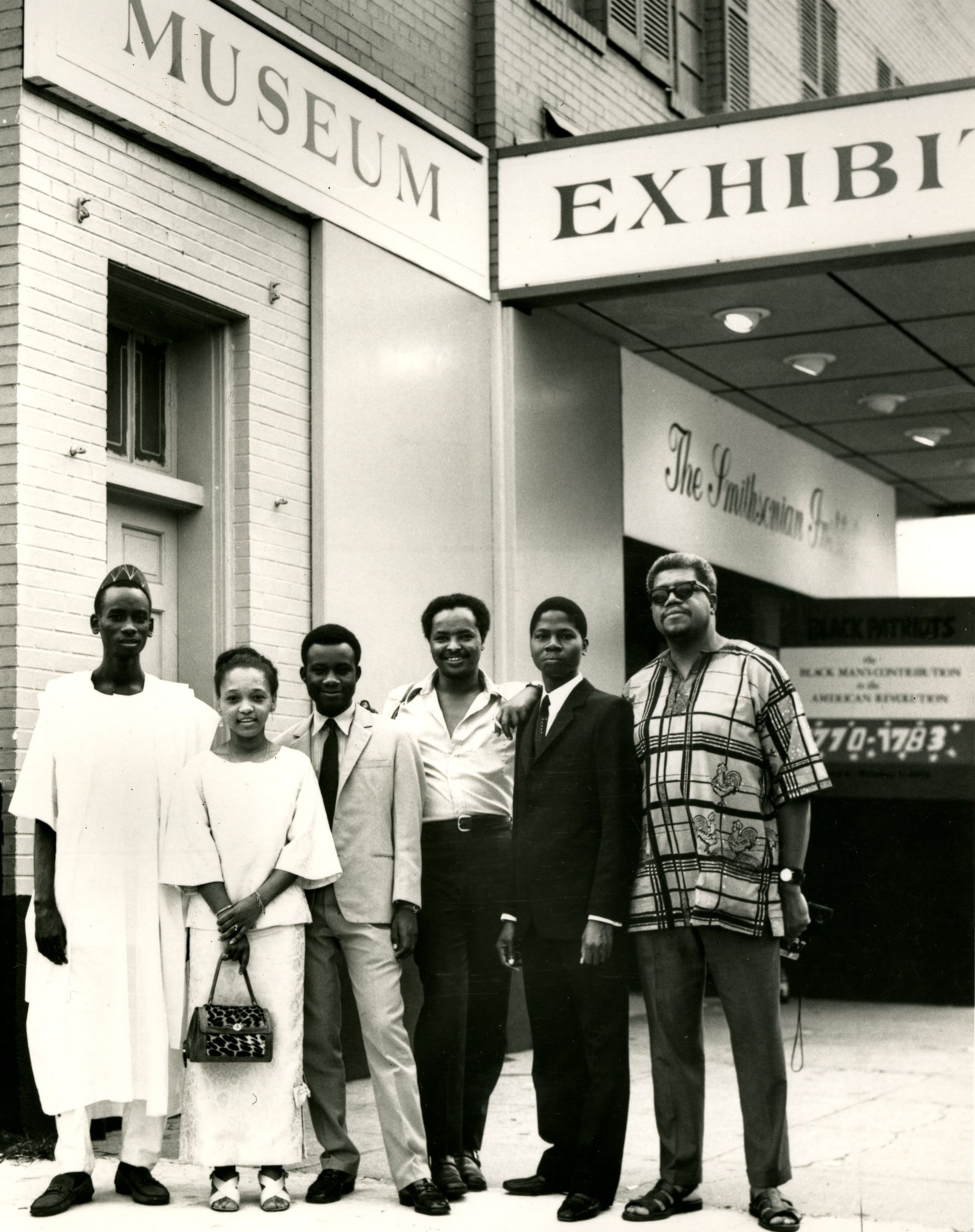Fellows, second from the left, stands with five men in front of the Museum, then at the Carver Theat