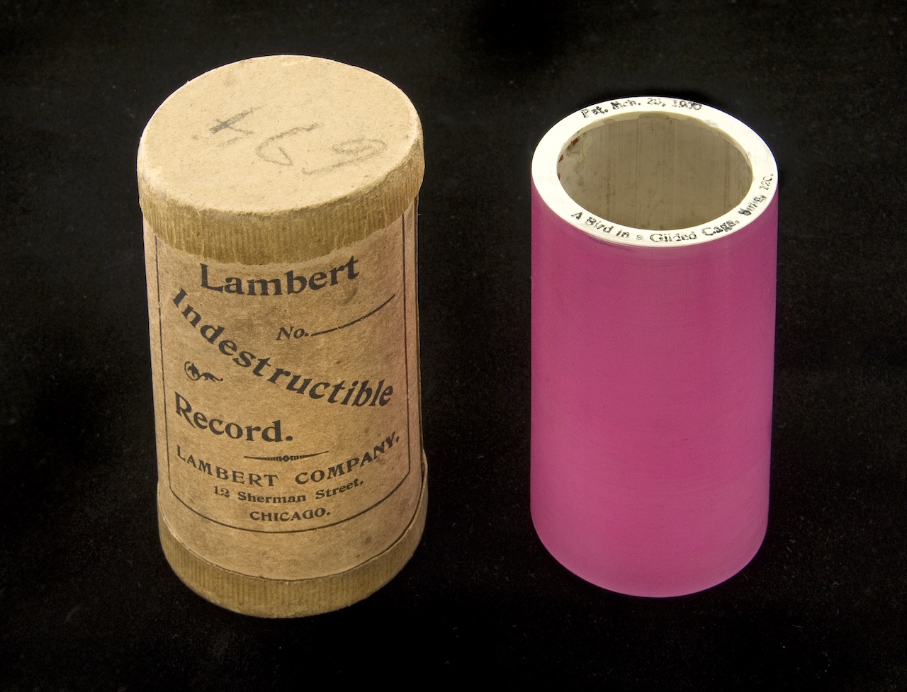 Lambert cylinder featuring "A bird in a gilded cage," possibly by Joe Natus.