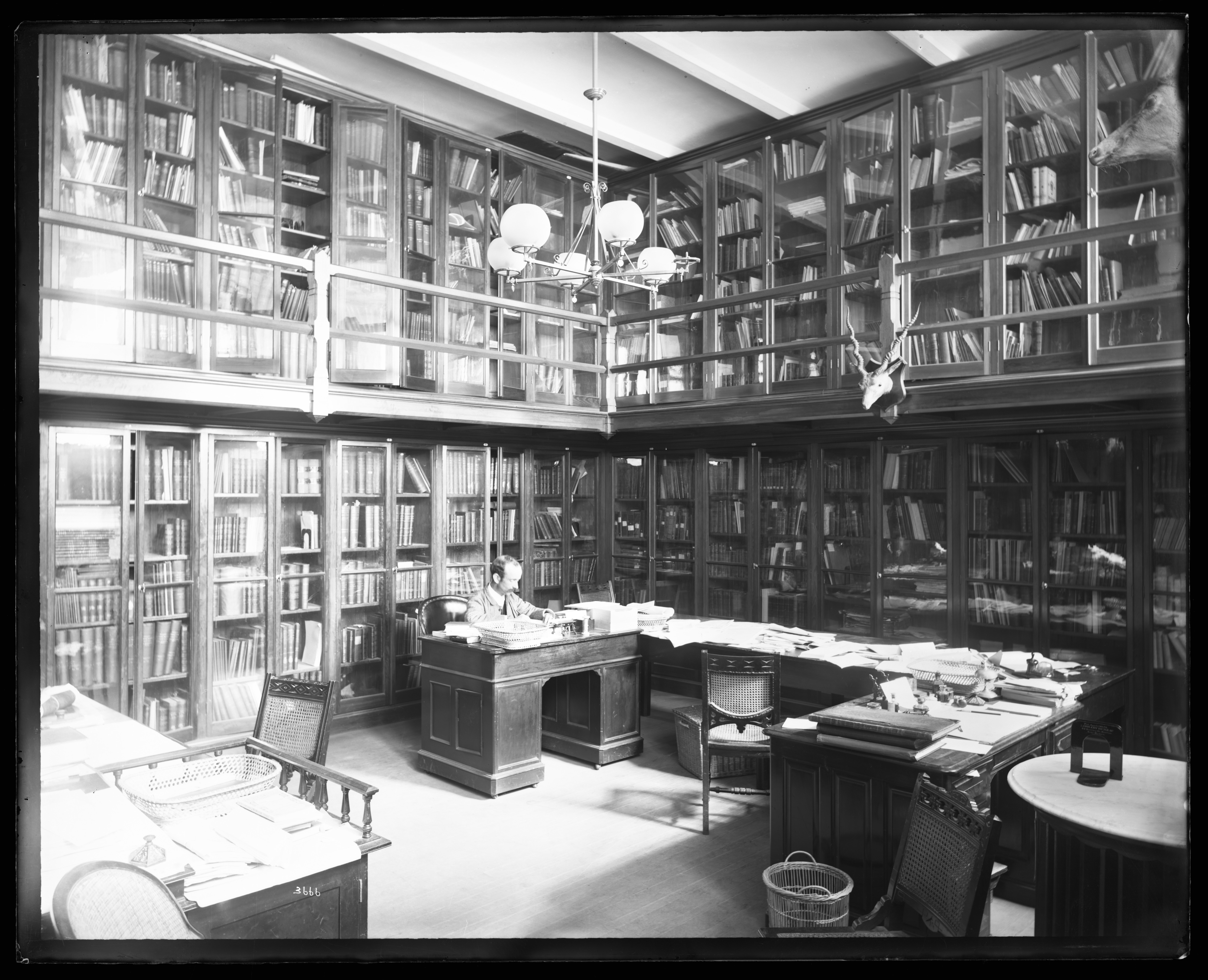 A man sits in a library. 