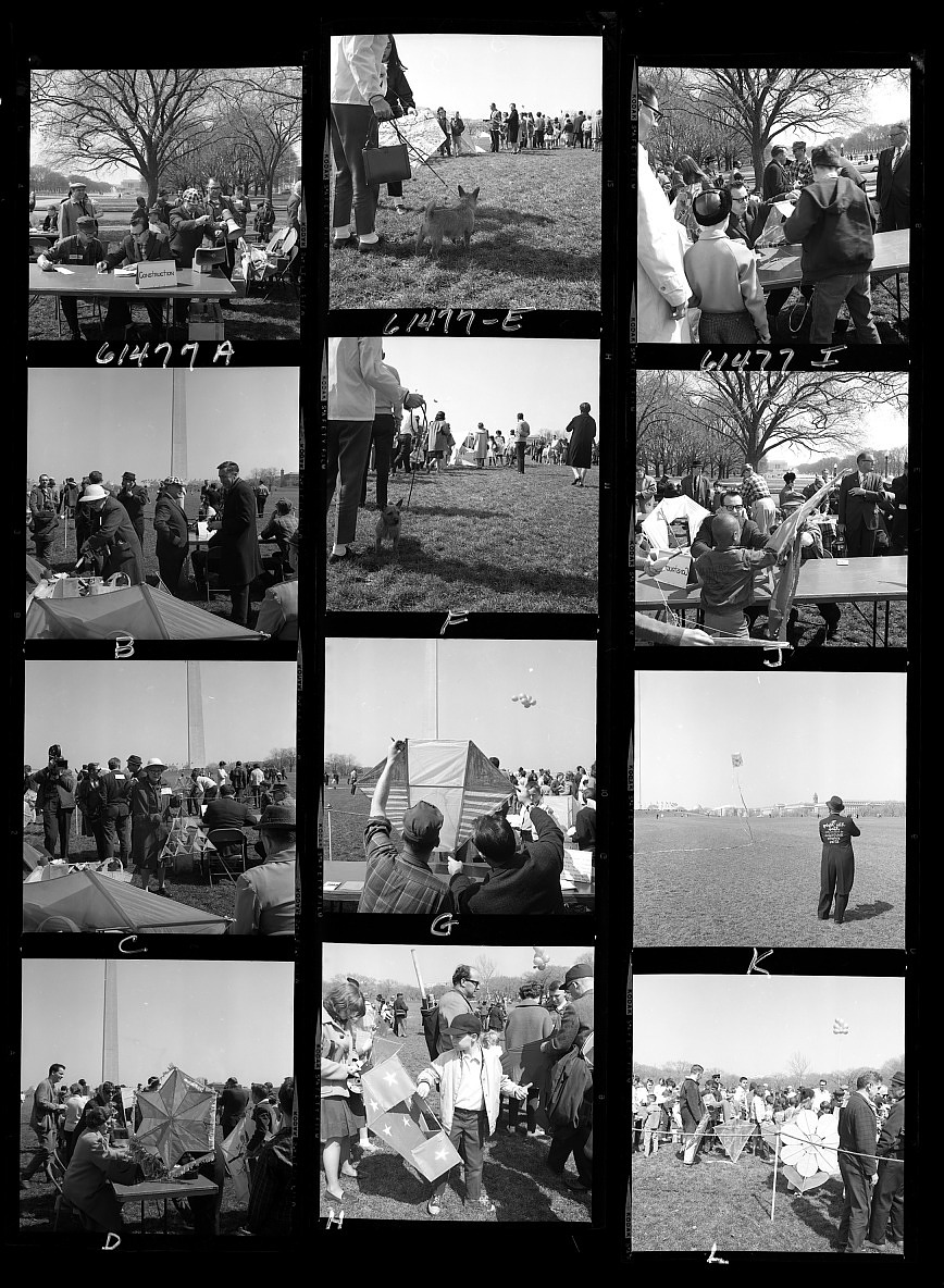 Twelve black-and-white film negatives of people enjoying a kite festival. The Washington Monument is