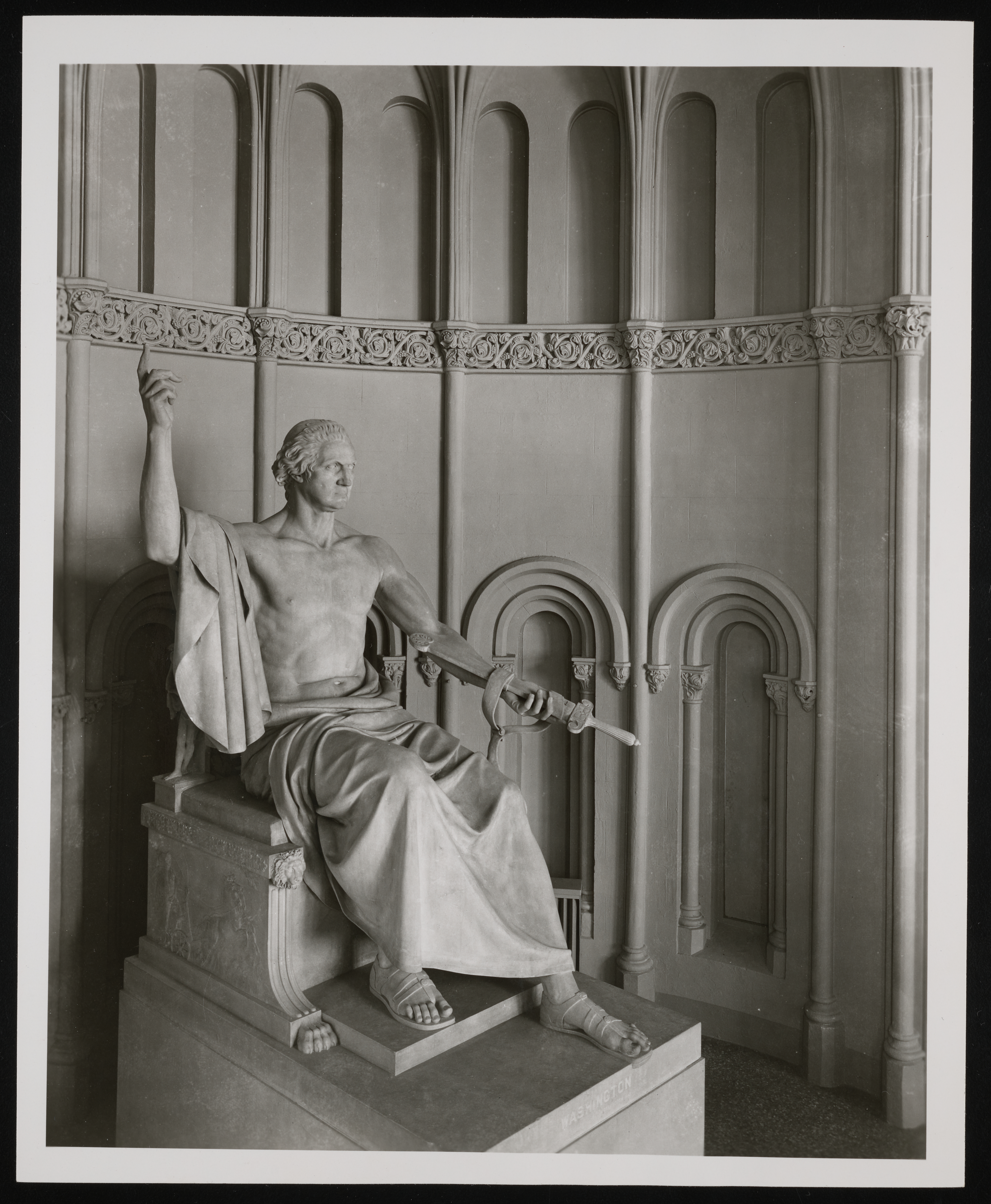 Statue of a toga-clad George Washington in the corner of a building. 