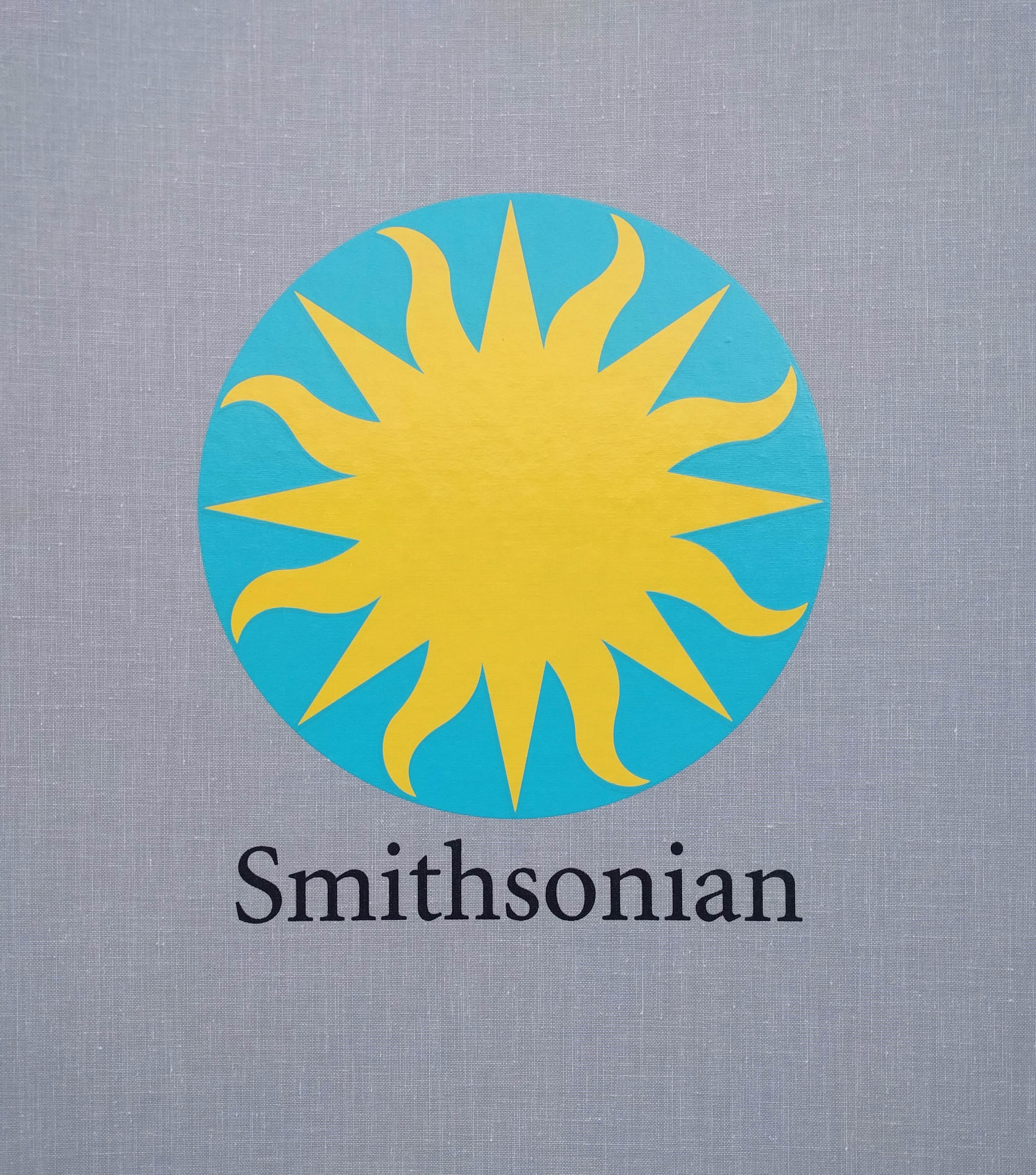 Teal circle with gold sunburst in center with Smithsonian text below