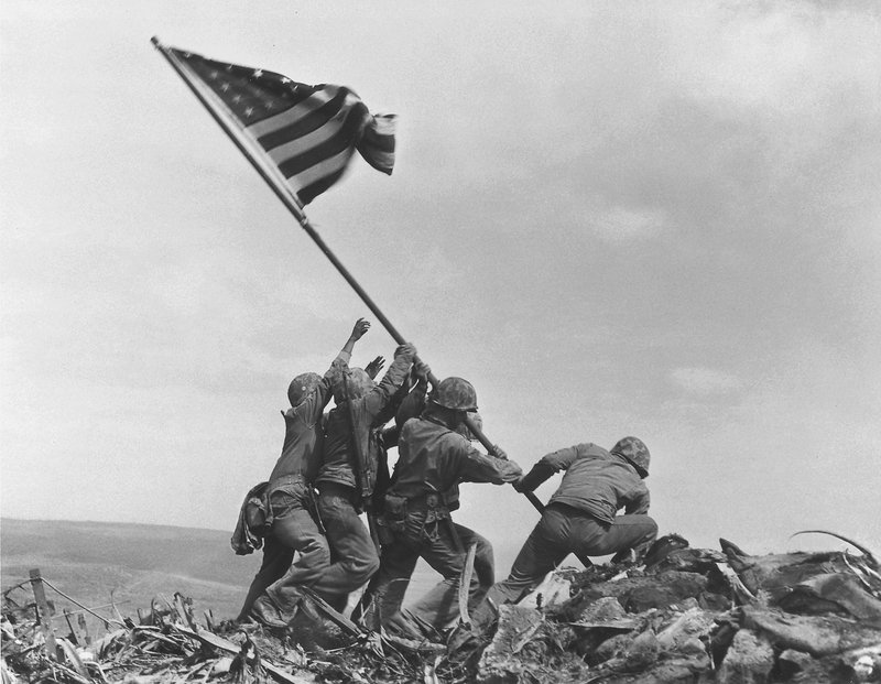 U.S. service members raise the American flag atop Mt. Suribachi in Iwo Jima, Japan, on Feb. 23, 1945.