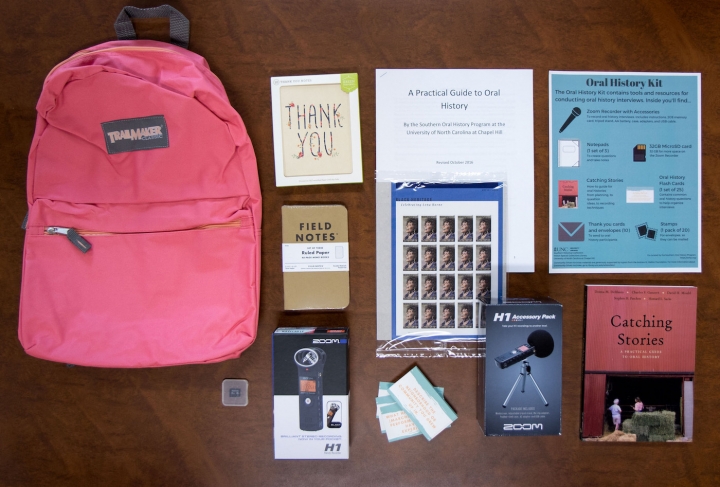 Pink backpack, field notes notebooks, microphone, audio recorder, and guides on recording oral histo