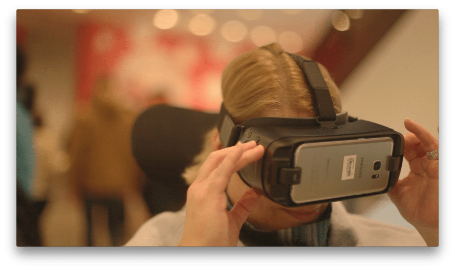 Color photo of woman using virtual headset smiling. 