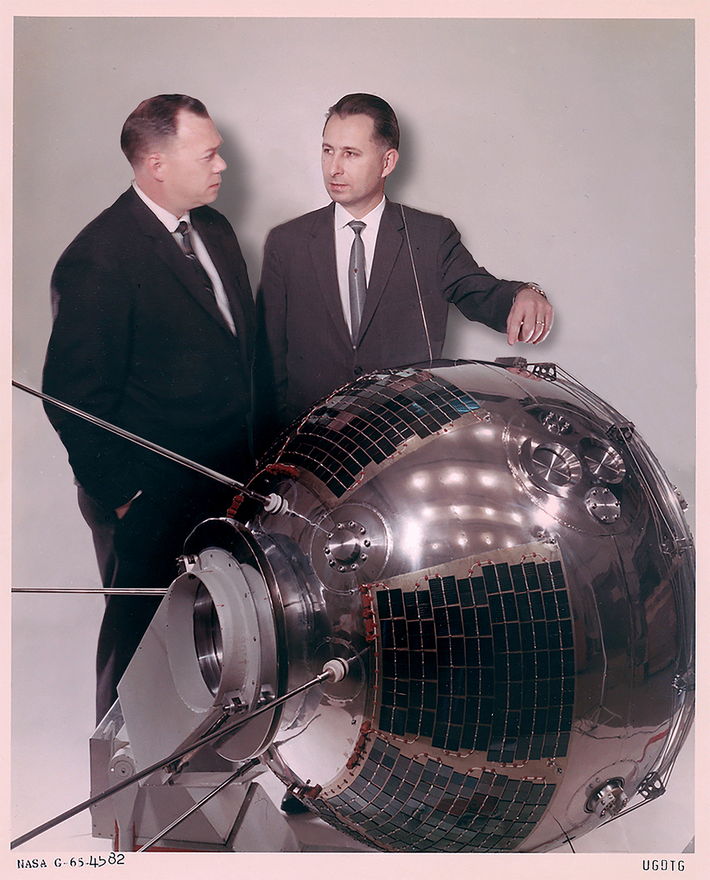 Animated photo of two men by space capsule, one man has finger on it while the other vaporizes.