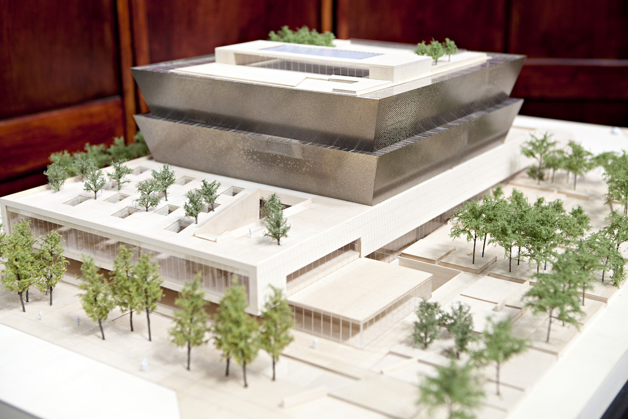 An architectural model that includes a display of trees and a building with two above ground tiers a