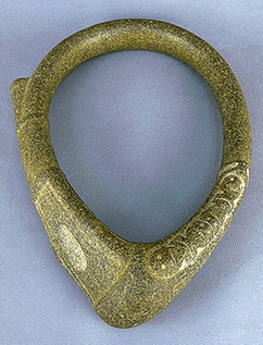 Image of carved, oval shaped collar artifact, with point at the bottom