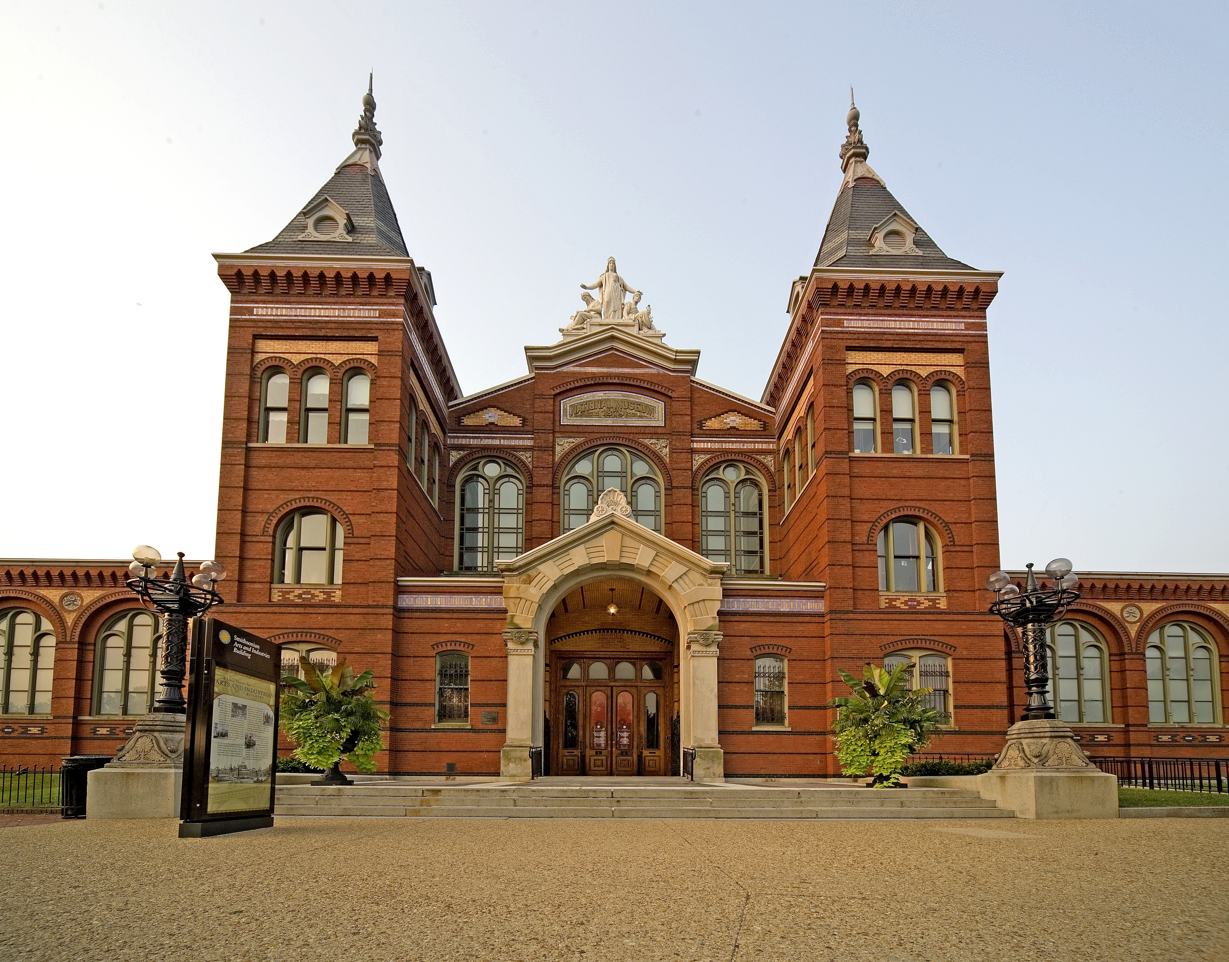 Visitors are entering and leaving the United States National Museum Building, now Arts and Industries Building, via the North Entrance.