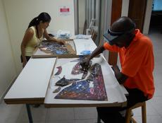 Conservation assistants Saori Kawasumi and Erntz Jeudy cleaning the painted surface.