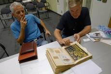 Clients with family memorabilia; a mother's wedding scrapbook and many photographs. Photo by Nora Lo