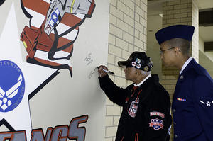 Captain Claude R. Platte, Tuskegee Airman, signs a wall at the 323rd Training Squadron dedicated to