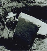 Photo of Marion Stirling next to an artifact that is being excavated