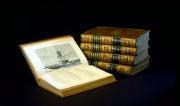 A stack of four volumes on the right and a fifth volume open to the left, with an image of a ship sh