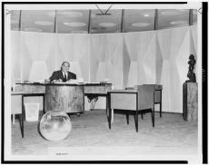 William Zeckendorf sits behind desk in his "cylindrical office" in New York City; World-Telegram pho