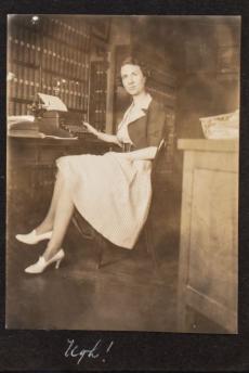 Young woman sitting at desk in office looking at the camera