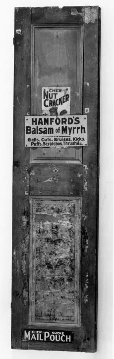 Shutter with three signs on it. The signs read: "Chew Nut Cracker," "Hanford's Balsam of Myrrh," and