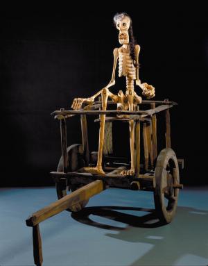 Wooden cart with seated skeleton.