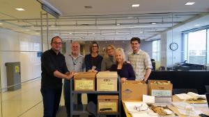 Seven volunteer standing shoulder-to-shoulder in a reading room.