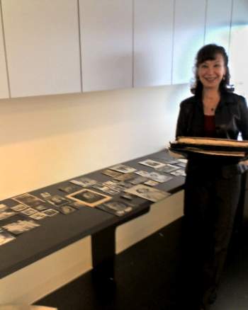 Woman next to array of photographs.
