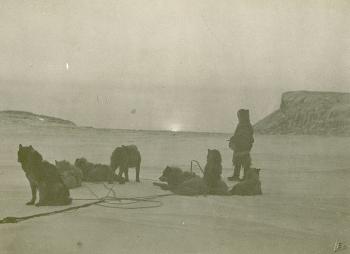 "Sunrise after a long winter." A man and his dogs gaze at the sun seen by the Rasmussen expedition 