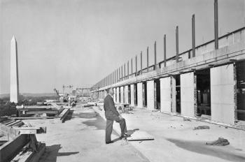 Frank A. Taylor standing on the fifth floor terrace and checking progress on construction of the Nat