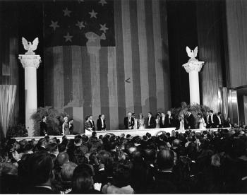 Guests standing in front of the Star-Spangled Banner at President Nixon's Inaugural Ball.