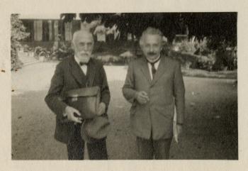 Black and white, slightly out of focus photograph of Lorentz and Einstein standing side by side out 