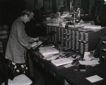 Edith E. Spaeth checking-in a serial using the kardex next to a card catalog, April 1948, National L