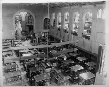 A large plane hanging in the Arts and Industries Building above rows of exhibit cases. That Statue of Freedom is also visible in the rotunda. 