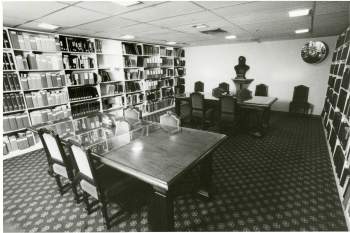 Photo of a reading room with books and manuscript boxes on the wall. 