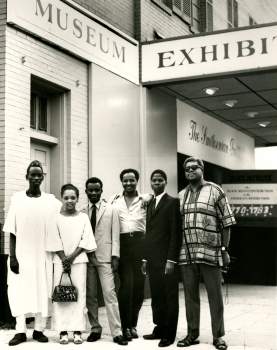 Fellows, second from the left, stands with five men in front of the Museum, then at the Carver Theater. 