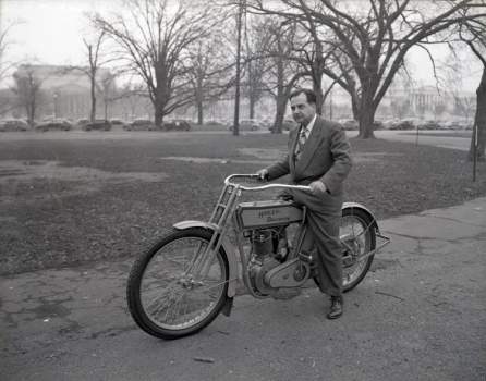 National Air Museum curator Paul Garber on a 1913 Harley Davidson motorcycle.