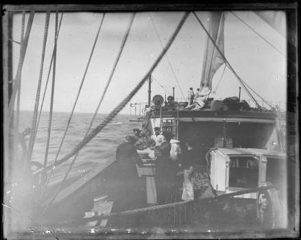 People work on the deck of the Albatross. The ship is sailing on a body of water.