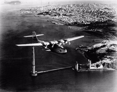 The China Clipper flies past the unfinished Golden Gate Bridge and heads toward Hawaii, November 22,