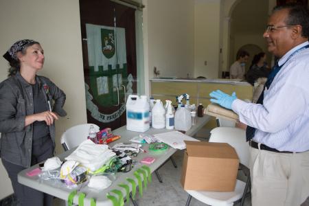 Two people standing around a table with conservation materials.