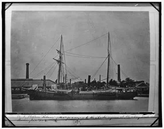 Black and white photograph of a docked ship. 